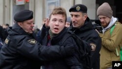 FILE - Police detain journalist Raman Pratasevich in Minsk, Belarus, March 26, 2017. Pratasevich, a founder of a messaging channel popular with the country's opposition, has been arrested after a plane in which he was a passenger was diverted to Minsk.