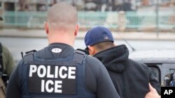 FILE - U.S. Immigration and Customs Enforcement (ICE) agents arrest foreign nationals, Feb. 7, 2017, in Los Angeles. In New York on Tuesday a lawyer threatened to call ICE because he heard cafe workers speaking Spanish.