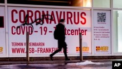 A woman walks past an abandoned coronavirus test center in Frankfurt, Nov. 2, 2021. Numbers of coronavirus infections are rising again in Germany.