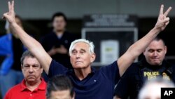 Mantan penasihat kampanye Presiden Trump, Roger Stone mengacungkan tanda "V" (victory) saat keluar dari pengadilan federal di Fort Lauderdale, Florida, Jumat (25/1). 