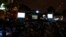 People take part in a virtual Islamic pilgrimage tour shown on giant screens, Istanbul, July 18, 2013.