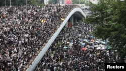 Protesters march along a road demonstrating against a proposed extradition bill in Hong Kong, China, June 12, 2019. 