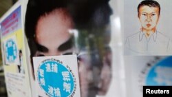 Poster pencarian buron Katsuya Takahashi diberi stiker bertuliskan "tertangkap" di sebuah kantor polisi di Tokyo (15/6). Takahashi, mantan anggota Aum Shin Rikyo, pelaku serangan gas sarin kereta api bawah tanah Jepang tertangkap di sebuah cafe buku komi