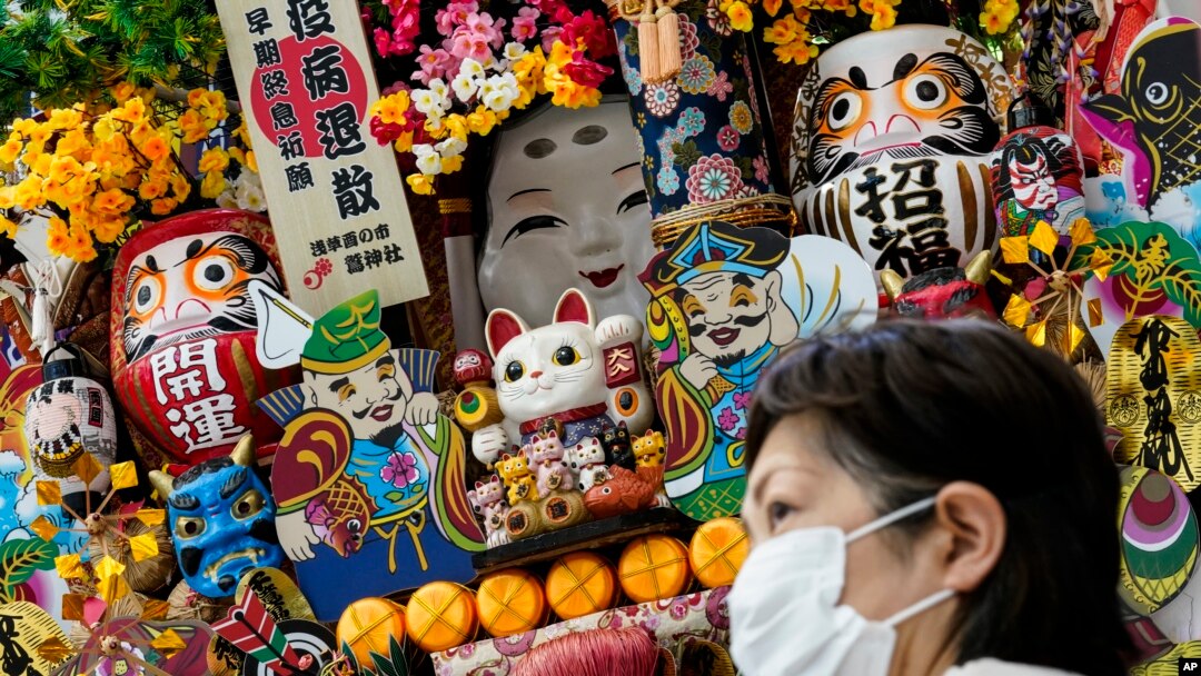 Seorang pelanggan yang mengenakan masker pelindung karena kekhawatiran COVID-19 mengantre di luar toko suvenir di Pusat Pers Utama pada Olimpiade Musim Panas 2020, Kamis, 22 Juli 2021, di Tokyo, Jepang. (Foto: AP)