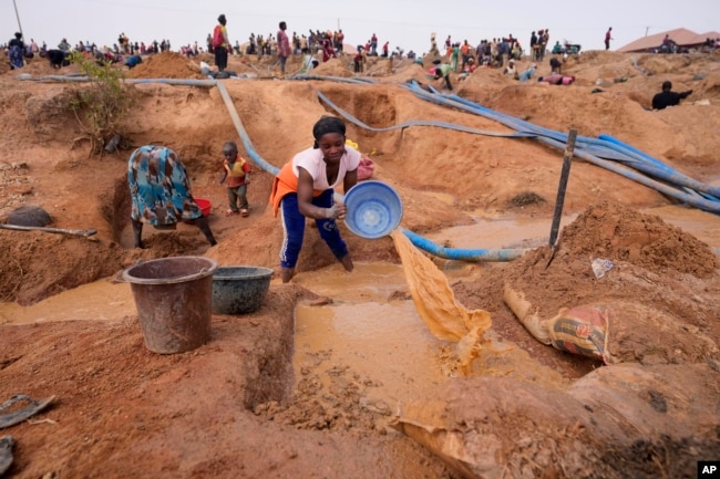 A woman works at an Illegal tin mining site in Jos, Nigeria, Wednesday, April 3, 2024. (AP Photo/Sunday Alamba)