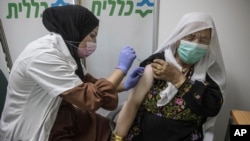 A Bedouin woman receives a Pfizer COVID-19 vaccine at a medical center in the Bedouin local council of Segev Shalom near the city of Beersheba, southern Israel, Dec. 30, 2020.