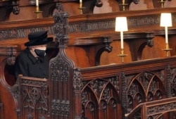 Britain's Queen Elizabeth II takes her seat for the funeral of Britain's Prince Philip, at St. George's Chapel, in Windsor, Britain, April 17, 2021.