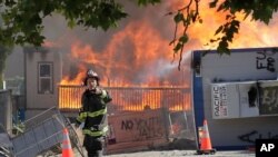 Construction buildings burn near the King County Juvenile Detention Center, July 25, 2020, in Seattle, shortly after a group of protesters left the area.
