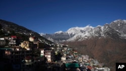 Joshimath town is seen along side snow capped mountains, in India's Himalayan mountain state of Uttarakhand, Jan. 21, 2023. For months, residents in Joshimath, saw their homes slowly sink. In January, big, deep cracks had emerged in over 860 homes, making them unlivable. 