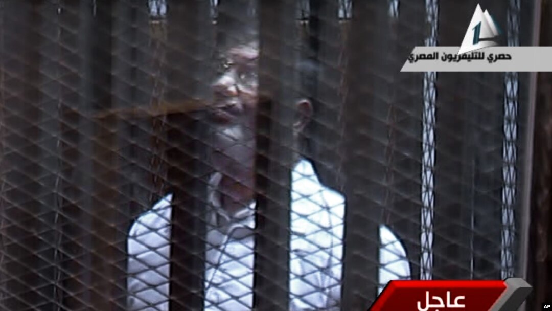 Video menunjukkan mantan Presiden Morsi berteriak-teriak ke arah hakim dari kurungan yang kedap suara (28/1).