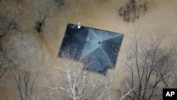 In this aerial photo, floodwater reaches the rooftop of a house in Valley Park, Mo., near St. Louis, Dec. 31, 2015.