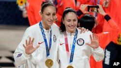 United States's Sue Bird, right, and Diana Taurasi pose with their gold medals during the medal ceremony for women's basketball at the 2020 Summer Olympics, Aug. 8, 2021, in Saitama, Japan.