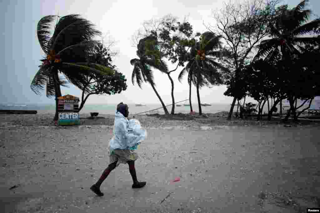 A woman protects herself from rain as Hurricane Matthew approaches in Les Cayes, Haiti, Oct. 3, 2016.