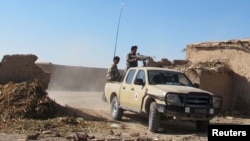 An Afghan National Army (ANA) soldiers drive at an outpost in Helmand province, Dec. 20, 2015. 