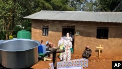 Ebola workers enter a house to decontaminate the body of a woman suspected of dying from Ebola, before the vehicle of the health ministry Ebola response team was attacked in Beni, northeastern Congo Monday, June 24, 2019.