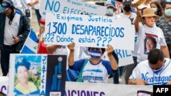 Un nicaragüense que vive en Costa Rica sostiene un cartel que reza "Nosotros exigimos justicia. 1300 desaparecidos, ¿dónde están?" durante una manifestación en San José, el 18 de abril de 2021.