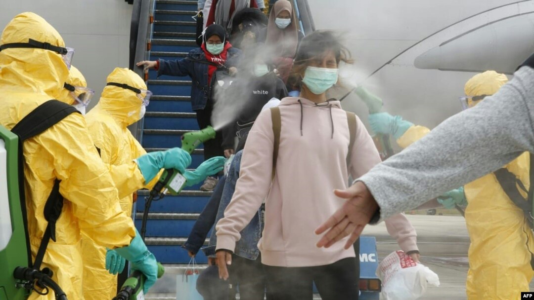 印度尼西亚政府2月2日派出包机将被困在武汉的印尼学生接回印尼。图为学生们下飞机时接受消毒处理。