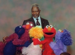 FILE - Several Muppets from the cast of "Sesame Street" surround United Nations Secretary General Kofi Annan as Annan taped an appearance for the PBS series in New York, Dec. 6, 2001.
