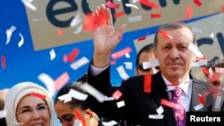 FILE - Turkey's President Tayyip Erdogan, accompanied by his wife Emine Erdogan, attends the opening ceremony of an imam-hatip school in Ankara, Nov. 18, 2014. 