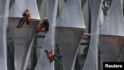 FILE - Construction workers climb a new building in London, Britain, April 11, 2017. The Metropolitan police says modern slavery is a problem in London, with workers in hotels, restaurants and on construction sites at particular risk of exploitation.