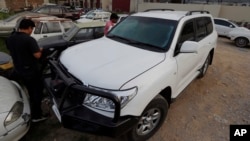 Pakistani journalists examine a car of American diplomat parked inside a police station after an accident in Islamabad, April 7, 2018.