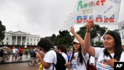 FILE - Daisy Leon, 26, right, of Perth Amboy, N.J., and a recipient of the Deferred Action for Childhood Arrivals program, attends a rally at the White House in Washington, Aug. 15, 2017, along with others in favor of DACA and immigration reform.