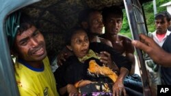 FILE —An injured elderly woman and her relatives rush to a hospital near the border town of Kutupalong, Bangladesh, Sept. 4, 2017. The mine blew of the right leg of the Rohingya woman as she tried to to cross into Bangladesh from Myanmar.