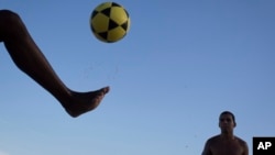 FILE: In this May 31, 2014 photo, a player controls a ball during a game of "altinho," where the goal is to keep the ball airborne while passed amid players.