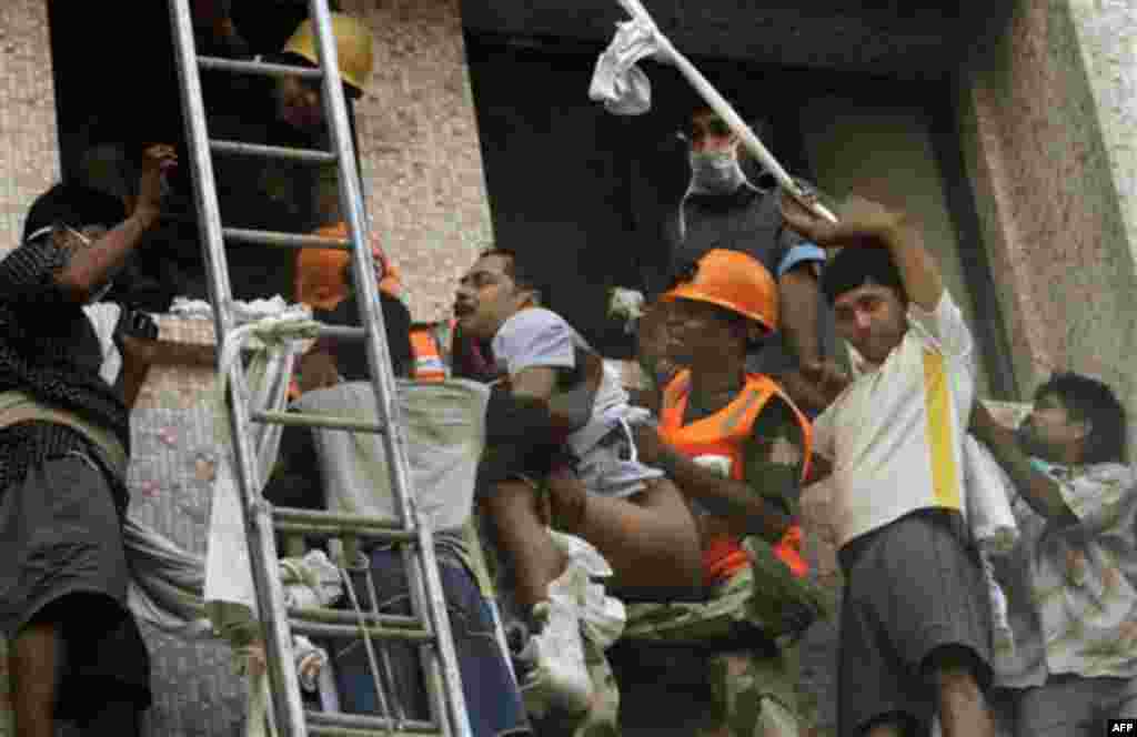Fire officials rescue a patient from the window of a hospital after it caught fire in Kolkata, India, Friday, Dec. 9, 2011. The fire swept through the multistory hospital in eastern India early Friday, trapping many elderly patients in the smoke-filled bu
