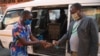 FILE - A man receives hand sanitizer as a preventive measure against the spread of the COVID-19 coronavirus before boarding a taxi in Gaborone, May 21, 2020.