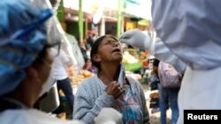 Personal del Ministerio de Salud de Guatemala realiza una prueba de Covid a una mujer en un mercado de productos frescos durante el brote de la enfermedad del coronavirus, en la Ciudad de Guatemala. 21 de mayo de 2020.