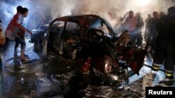 People gather at the site of an explosion at the southern suburbs of the Lebanese capital Beirut, June 23, 2014.