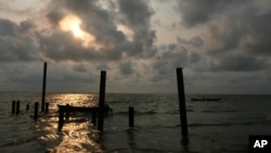 Locals fish at sunset in the creeks of the oil rich Bakassi Peninsula, August 11, 2006. 