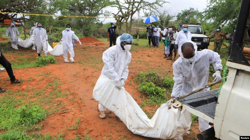 Des experts médico-légaux et des détectives transportent les corps de membres présumés d'un culte chrétien nommé Good News International Church, qui croyaient qu'ils iraient au paradis s'ils mouraient de faim.