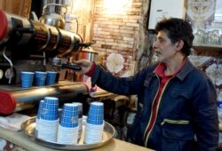 A man prepares some coffees for customers in a cafe of Tunis, Tuesday May 26, 2020.