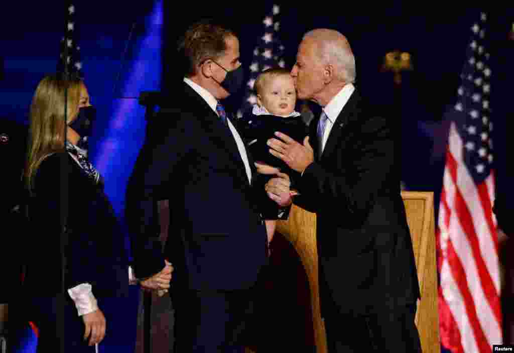 Democratic 2020 U.S. presidential nominee Joe Biden kisses a relative after speaking at his election rally, after the news media announced that Biden has won the 2020 U.S. presidential election.