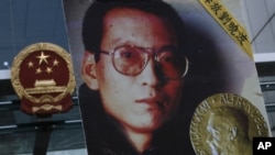 ຮູບພາບ ຂອງທ່ານ Liu Xiaobo ທີ່ພວກປະທ້ວງຖື ໃນຂະນະຮຽກຮ້ອງໃຫ້ປ່ອຍໂຕຜູ້ກ່ຽວ ຢູ່ນອກ ສຳນັກງານພົວພັນຂອງຈີນ ປະຈຳຮົງກົງ. ທ່ານ Liu ອາຍຸ 61 ປີ, ໄດ້ຖືກສານຕັດສິນລົງໂທດ ໃນປີ 2009 ໃຫ້ຈຳຄຸກ 11 ປີ
ຍ້ອນການເຄື່ອນໄຫວຕໍ່ສູ້ເພື່ອປະຊາທິປະໄຕ ຢູ່ໃນຈີນ. 
