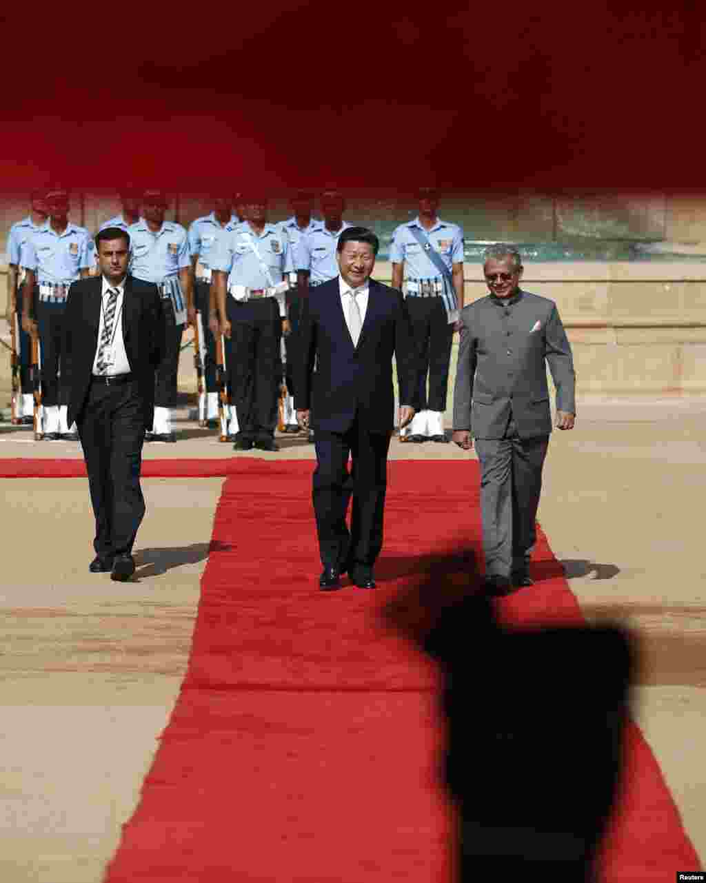 Chinese President Xi Jinping (center) walks on the red carpet after inspecting a guard of honor during his ceremonial reception at the forecourt of the Rashtrapati Bhavan presidential palace in New Delhi, Sept. 18, 2014. 