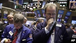 Traders Richard Newman, left, and David O'Day work on the floor of the New York Stock Exchange, June 14, 2011 (file photo)