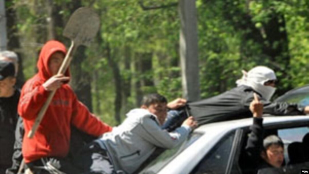 Kelompok etnis Kyrgyz tampak mengendarai mobil di ibukota Bishkek dengan bersenjata pentungan, 19 April 2010.