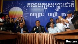 Sam Rainsy (tengah), pemimpin partai oposisi CNRP (Cambodia National Rescue Party) memberikan sambutannya di kantor pusat CNRP, Phnom Penh (29/7). Partai oposisi utama Kamboja ini menolak hasil pemilu nasional Kamboja yang menyatakan kemenangan partai PM Kambja, Hun Sen.