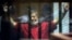 FILE - Former Egyptian President Mohamed Morsi, wearing a red jumpsuit that designates he has been sentenced to death, raises his hands inside a defendants cage in a makeshift courtroom at the national police academy, in an eastern suburb of Cairo.