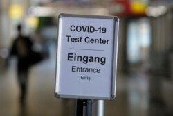 A sign helps passengers to find the COVID-19 test center at the airport Tegel in Berlin, Germany, Aug. 8, 2020.