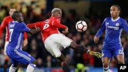 Paul Pogba, de Manchester United, contrôle le ballon sous l’œil vigilant de N'Golo Kante de Chelsea, à gauche, et Willian, à droite, pendant le match de quart de finale de la coupe de la ligue anglaise entre Chelsea et Manchester United au Stade Stamford 