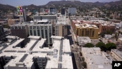 FILE - Apartment buildings line the streets in Los Angeles, July 30, 2018. Millennials are rejecting larger, expensive metropolises for smaller cities that offer more affordable housing and a lower other cost of living, according to a new report.