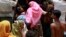 People from a Rohingya internally displaced persons (IDP) camp board a vehicle to their camp after waiting out cyclone Mahasen in a mosque outside of Sittwe, Burma, May 17, 2013. 