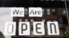 USA, Columbus, Ohio, A "we are open" sign is placed in the window of a restaurant as Ohio