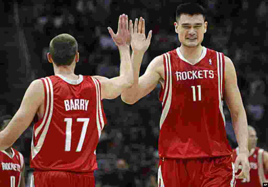 Houston Rockets Yao Ming (11) high fives teammate Brent Barry (17) during the fourth quarter of their NBA basketball game against the Cleveland Cavaliers in Ohio, Dec. 23, 2008 (Reuters).