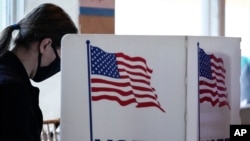 FILE - A young voter casts her ballot on Election Day in Atlanta, Georgia, Nov. 3, 2020.