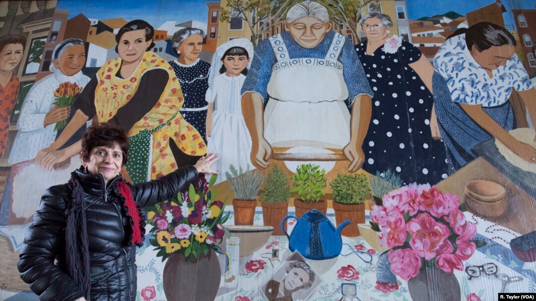 Diane Modica points to her younger self, standing beside her late "nonna," an early 20th-century immigrant from Sicily. She and her grandmother were included in the City of Boston's "Immigrant Grandmothers" mural in East Boston. 